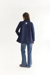 Blazer azul marino de tela agamusada, corte clásico, con solapas y bolsillos frontales.