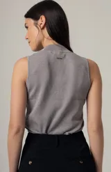 Musculosa negra con cuello alto y detalle de botones decorativos en el lateral.