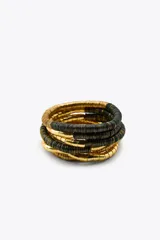 Set de seis pulseras elásticas con piezas tubulares combinadas en dorado y negro.