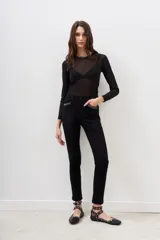 Pantalón jean negro de corte slim con detalles de tachas plateadas en los bolsillos delanteros y en el ruedo.