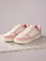 Championes de mujer color rosa y blanco con detalle de la inscripción 'EST 1983' en el lateral.