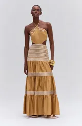 Vestido largo color ocre sin mangas, confeccionado en tricolina con forro. Presenta bordados en madera, hilo y pedrería, abertura en la cintura y tira para atar al cuello.