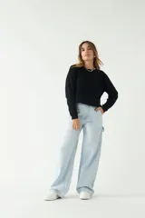 Sweater negro de punto con textura acanalada, cuello redondo y corte relajado.