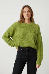 Sweater de tejido punto calado con diseño de hojas o espigas, color verde lima. Presenta cuello redondo y mangas largas con puños anchos.