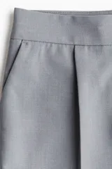 Short pollera corto de sastre color gris, con pinzas frontales, pretina ancha con cierre y corchetes, y bolsillos al bies.