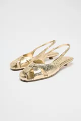 Sandalias doradas con tiras cruzadas en el empeine, tira trasera y tacón kitten heel.