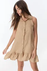 Vestido corto color ladrillo, sin mangas, con cuello camisero con volados, abotonado al frente y falda con volados.