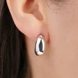 Aros colgantes dorados con forma de lágrima.