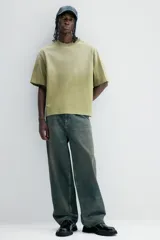 Remera de algodón color verde con efecto desteñido, corte amplio, cuello redondo y mangas cortas.