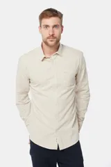 Camisa de lino color beige, de manga larga, con cuello clásico y bolsillo en el pecho.