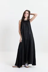 Vestido largo negro con estampado abstracto, de silueta amplia, con breteles finos y escote redondeado. Tiene un frunce sutil en el escote delantero y trasero que genera una caída fluida y relajada.