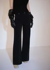 Pantalón de pana negro, de corte wideleg, tiro medio y cinco bolsillos. Cierre frontal con cremallera y botón, trabillas en la cintura.