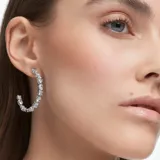 Aros tipo argolla Swarovski Mesmera, bañados en rodio y engarzados con circonias blancas de diferentes tallas.