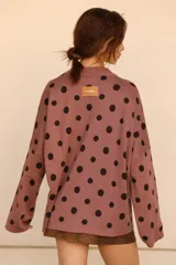 Sweater de punto color lavanda con estampado de lunares negros y diseño holgado.