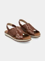 Sandalia marrón con textura croco, tiras cruzadas y ajuste elástico en el talón.