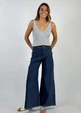 Pantalón de mezclilla laminada dorada con corte amplio y detalle de costuras visibles.