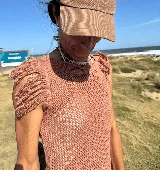 Musculosa tejida color ladrillo, con diseño calado y flecos en los hombros.