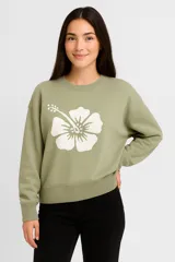 Sweater verde con estampado de flor blanca, cuello redondo y corte holgado.