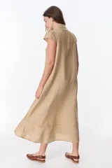 Vestido camisero celeste de lino, corte midi, con cuello camisero, mangas cortas con volados y abotonadura frontal.