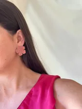 Aros con forma de flor color salmón con brillo.