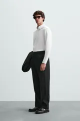 Camisa negra de manga larga, corte slim fit, con cuello italiano y cierre frontal de botonadura.