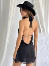 Vestido corto negro con escote halter y espalda descubierta.