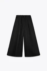 Pantalón culotte negro de tiro medio con cintura elástica y bolsillos laterales ocultos en la costura.