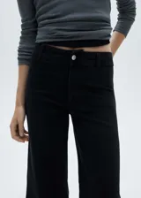 Pantalón culotte de tiro alto color negro, con cierre de cremallera y botón, trabillas, bolsillos traseros, bajo deshilachado y tejido elástico.