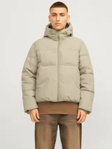 Campera puffer color beige con capucha ajustable, cierre de cremallera, bolsillos frontales y puños acanalados.
