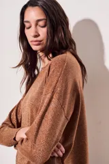 Sweater color camel con brillo, de calce al cuerpo, suave y liviano.