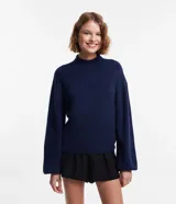 Suéter corto azul marino de punto liviano, con cuello alto, manga larga y puños ajustados.