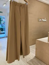 Pantalón liso verde con recorte delantero, botón al tono y cintura elástica con pasacinto.