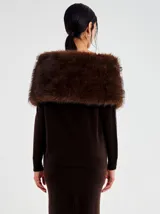 Chal envolvente de pelo sintético color marrón, con diseño cruzado sobre los hombros y textura suave y voluminosa.