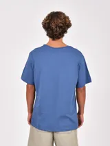 Remera de manga corta color verde oliva, con cuello redondo y un bolsillo frontal en el pecho.