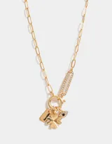 Collar corto dorado con cadena de eslabones y multidijes: candado con corazones dorados, dedal plateado, mano negra, cuentas de cristal, pez plateado, borla de cordones verdes y dije de luna plateada.