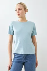 Remera de manga corta color gris claro con logo pequeño en la manga.