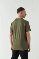 Chomba azul marino de manga corta con cuello polo y detalles de líneas grises en cuello y mangas. Tiene logo bordado en el pecho. Corte regular.