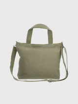 Bolso tipo tote de lona color verde oliva con doble asa de mano y correa bandolera ajustable y extraíble. Estampado frontal con un perro basset hound y el logo de la marca Hush Puppies.