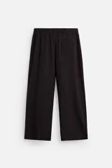 Pantalón relaxed fit color marrón oscuro confeccionado en tejido con mezcla de algodón y lino. Cintura elástica, bolsillos laterales y bolsillo trasero de plastrón. Perneras con pliegues frontales. Cierre en delantero con cremallera y botón.