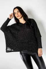 Poncho negro tejido en lurex, de calce suelto y relajado.