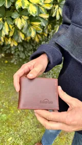 Billetera de cuero color marrón con el logo de la marca SierraMora grabado en la parte inferior.