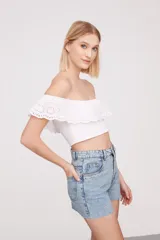 Top blanco strapless con volado de broderie con calados.