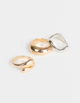 Set de tres anillos de metal, uno dorado con forma de espiral, uno dorado liso y uno plateado con forma irregular.