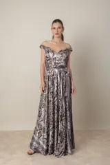 Vestido largo de satén de seda estampado en tonos chocolate y natural, con escote off-shoulder y falda con movimiento. Incluye lazo para ajustar la cintura y tul transparente en el escote.