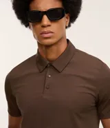 Camisa polo negra de manga corta, confeccionada en poliamida y elastano, con cuello inglés abotonado y tecnología Performance que proporciona mayor comodidad térmica, elasticidad y secado rápido.