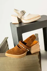 Zapato negro de gamuza con taco de madera y detalle de tachas doradas.