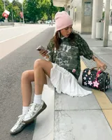 Championes plateados de cuero con detalles en blanco, suela marrón y cordones blancos.