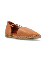 Alpargatas de cuero color marrón claro con suela de yute y tiras elásticas cruzadas en el empeine. Diseñadas en Uruguay y fabricadas en Turquía.