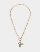 Collar dorado con cadena de eslabones y cierre de aro con barra en la parte delantera. Incluye dijes colgantes: piedra verde ovalada con diseño de hojas, ojo turco y corazón dorado con textura.