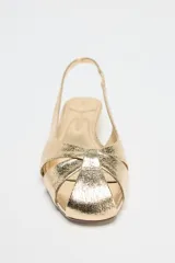 Sandalias doradas con tiras cruzadas en el empeine, tira trasera y tacón kitten heel.